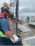 A person in a hard hat using a tablet

Description automatically generated