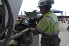 A person in a hard hat working on a truck

Description automatically generated